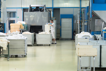 Man working in launderette sorting laundry