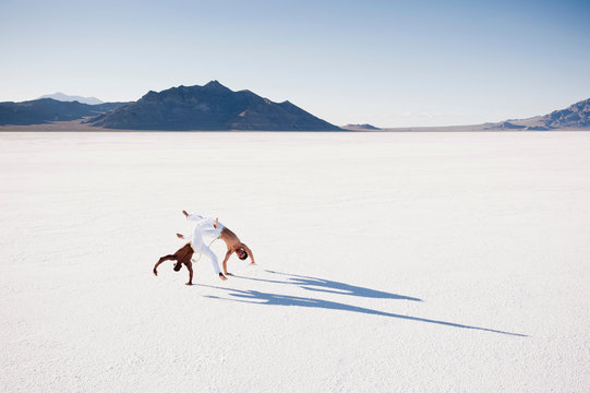 Elevated view of two men performing capoeira on Bonneville Salt Flats, Utah, USA