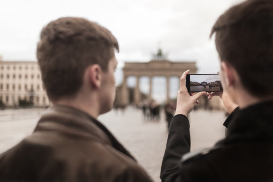 Two teenagers taking a smartphone image of the Brandenburg Gate in Berlin