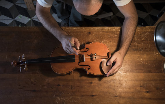 Luthier adjusting the sound post of a violin in his workshop