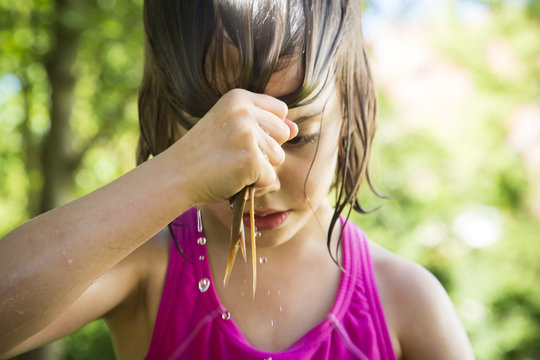 Little girl wringing out her wet hair