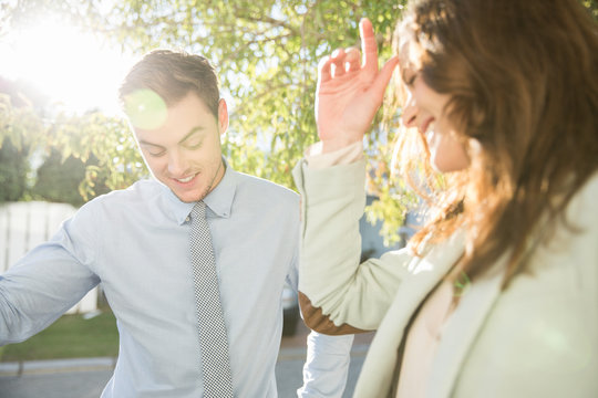 Embarrassed Flirty Young Businesswoman And Man On Sunlit Street