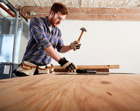 Carpenter in workshop using hammer