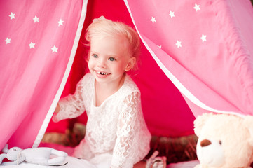 Smiling kid girl 3-4 year old sitting in tent outdoors