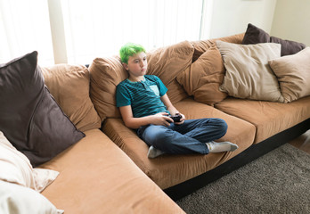 Boy playing video game on sofa