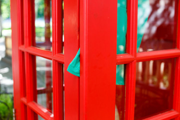 Fototapeta na wymiar dress clamped door of red telephone box. she quickly hopped into a phone box, was in a hurry to call. dress clamped door red telephone booth. communication concept 