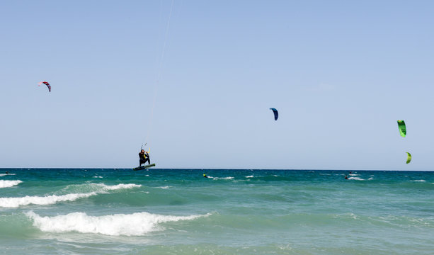 People practicing kitesurf on the beach of Torre Canne