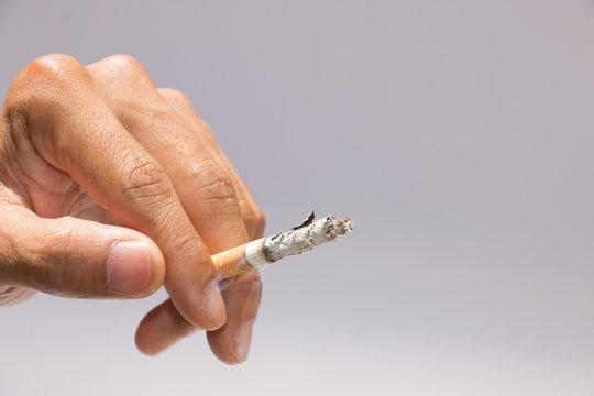 Smoking cigarette with hand closeup

