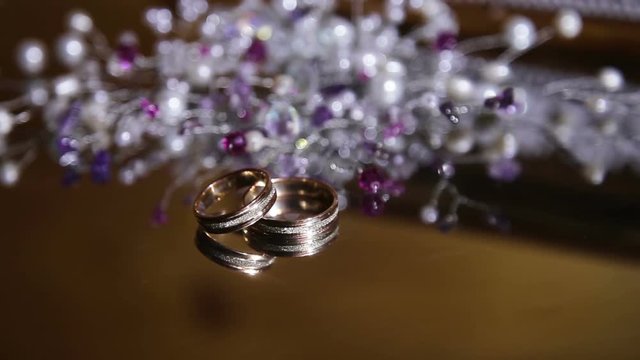 Two beautiful wedding rings on glass, mirror table.Wedding concept.