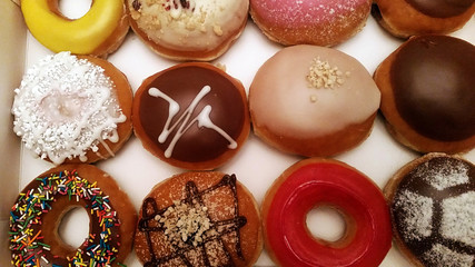 Sweet delicious donuts of different colors in stock