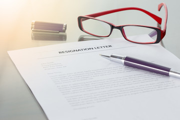 Resignation letter information with pen and glasses.