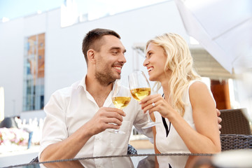 happy couple drinking wine at open-air restaurant