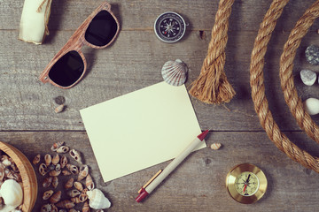 Travel items on wooden table. Notebook blank page mock-up with T