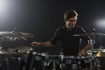 Fototapeta na wymiar Young Drummer Playing Drum Kit In Studio