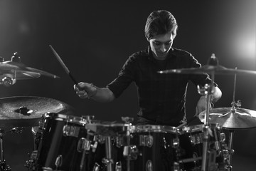 Fototapeta na wymiar Black And White Shot Of Drummer Playing Drum Kit In Studio