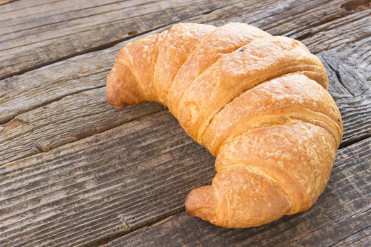 Croissant on wooden background