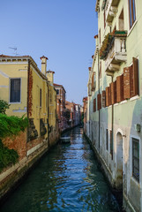 Obraz premium Narrow canal among old colorful brick houses in Venice, Italy