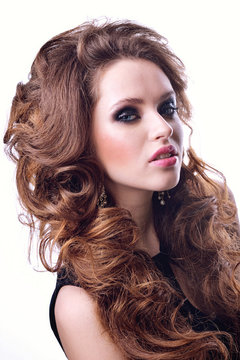 Beautiful model with long curly hair . fashion trend image ,the girl with blue eyes , fashion makeup and Hairstyle curls