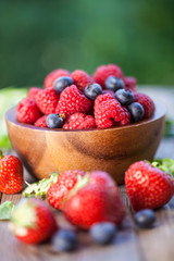 fresh raspberries, blueberries and strawberries on wooden background