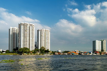 Fototapeta na wymiar Cityscape with modern building near the river in the afternoon at Chao Phraya River in Bangkok, Thailand