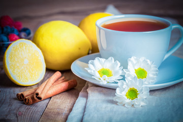 Toned photo. herbal tea with chamomile and lemon on a wooden table