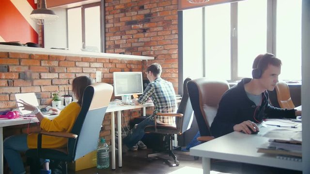 Team of designers working on computer together in their office