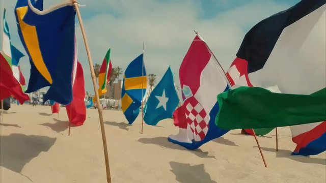 Beautiful pan of flags from different countries on the beach