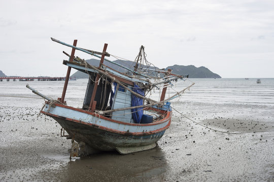 traditional fishing boat laying on a beach near the sea with mountain and island, selective focus,filtered image