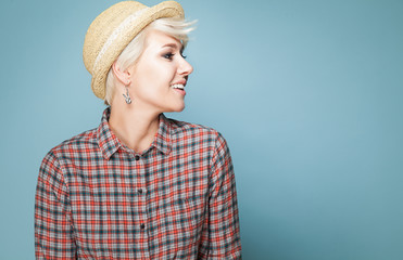 Young fashion smiling girl hipster with short blond hair in hat and shirt