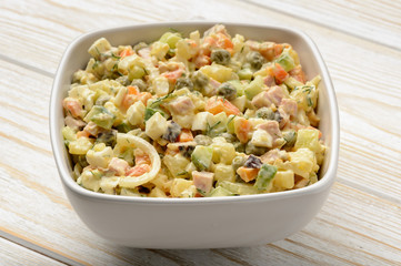 Vegetable salad with eggs, carrot, potatoes, green peas, cucumbers and dressing.