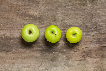 Green apples on a wooden background. Top view.