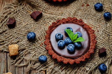 Fototapeta na wymiar chocolate tartlets with chocolate filling and fresh blueberries