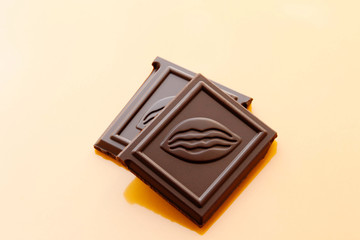 Chocolate pieces on a yellow background. Dessert. World Chocolate Day.