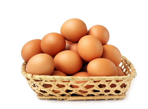 Brown eggs in basket on white background.