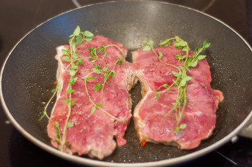beef steak fried in a skillet with timyanom
