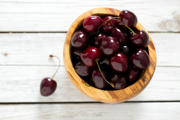 ripe red cherries on wooden surface