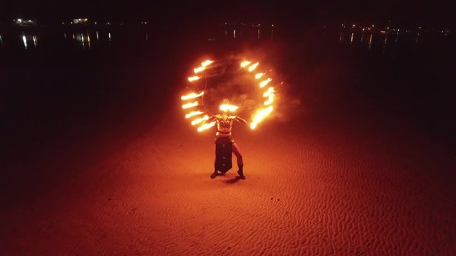 Dancing fire show on the beach at sunset