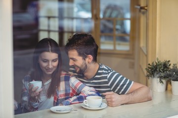 Cheerful couple talking at coffee shop