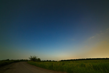 Country road on a background of the starry night sky.