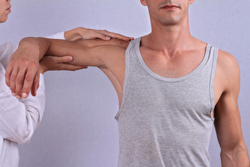 Chiropractic, osteopathy, manual therapy. Therapist doing healing treatment on man's hand /...