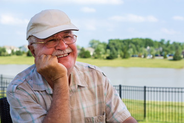 Happy elderly man sitting on an outdoor patio