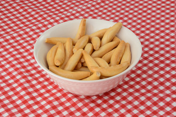 Toasted bread sticks (picos camperos) in white bowl on tablecloth