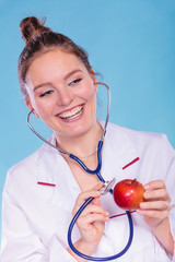 Dietitian examine apple fruit with stethoscope.