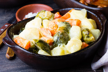 Rustic baked vegetables in clay bowl