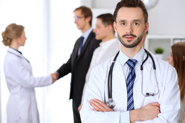 Fototapeta premium Friendly male doctor on the background doctor and patient shaking hands. Medical trust and ethics concept