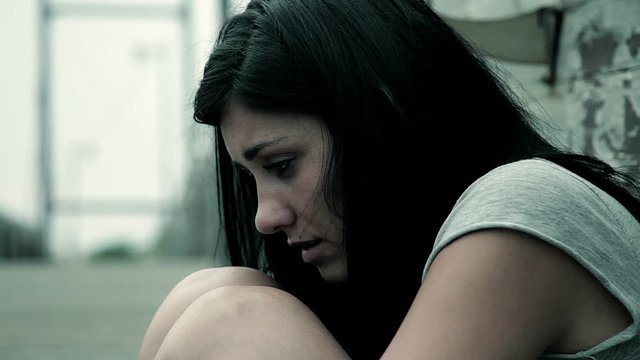 Sad desperate woman feeling lonely sitting on street