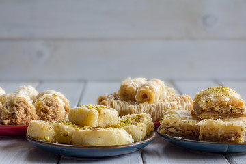 Variety of Baklava on Plates Horizontal on Wooden Table with Copy Space Selective Focus