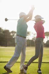 Mature male golf player teaching woman