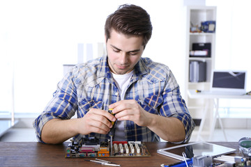 Man fixing electronic circuits in service center