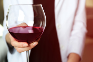 Woman holding glass of wine, closeup